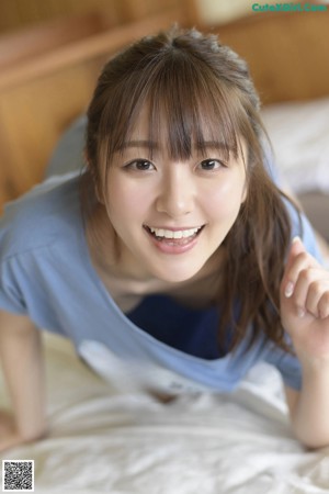 A naked asian woman sitting on a bed.