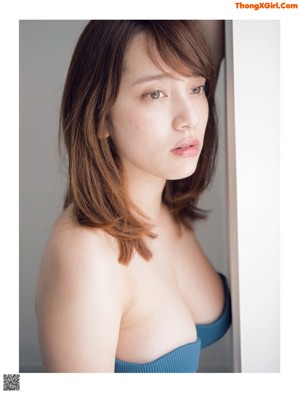 A woman in a blue bra is posing for the camera.