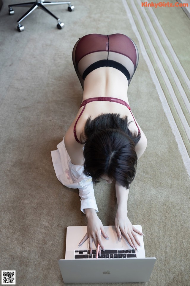 A woman laying on the floor using a laptop computer.