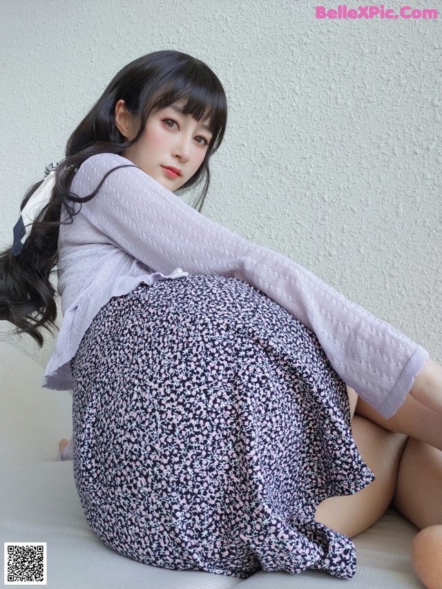 A woman sitting on top of a white couch.