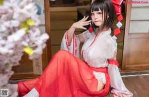 A woman in a red and white kimono posing for a picture.