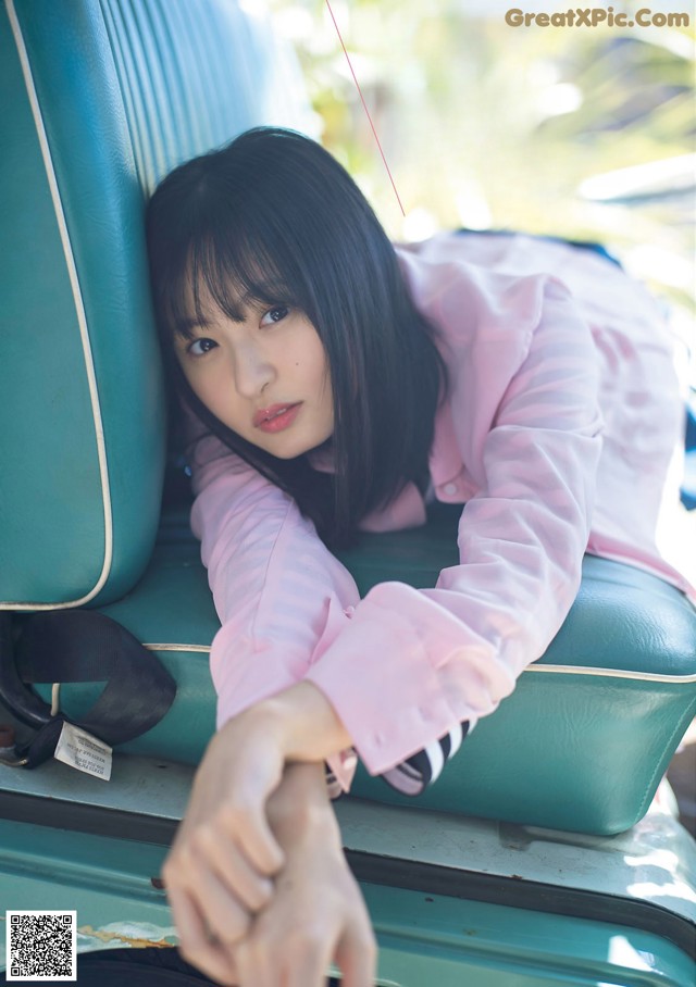 A woman sitting in the back seat of a car.