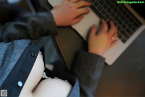 A woman sitting at a desk with a laptop computer.