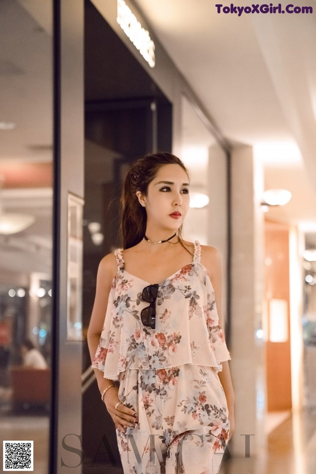 A woman standing in front of a glass door.