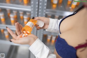 A woman sitting on a ladder in a pharmacy.