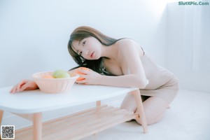 A woman sitting on top of a white bed.