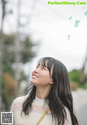 A young woman holding an orange on a swing.