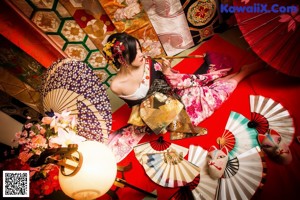 A woman in a kimono holding an umbrella on a city street.