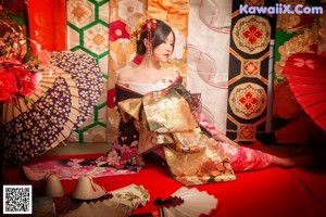 A woman in a kimono poses for a picture. 