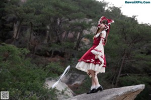 A woman in a red and white dress holding a sword.