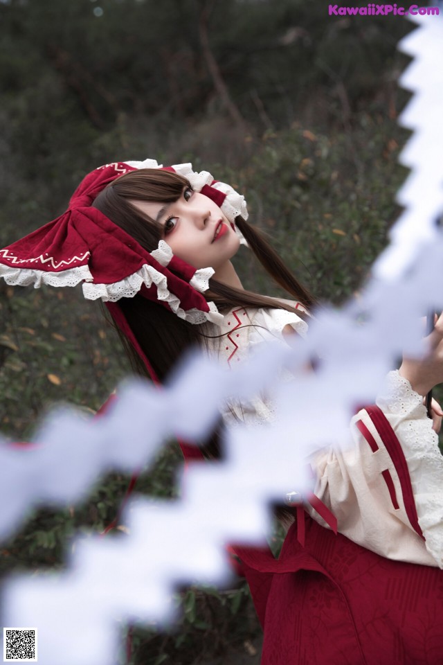 A woman in a red and white dress holding a sword.