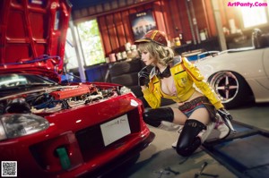 A woman in a yellow jacket and hat holding a wrench.