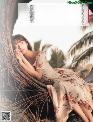 A woman in a pink dress sitting on the floor.