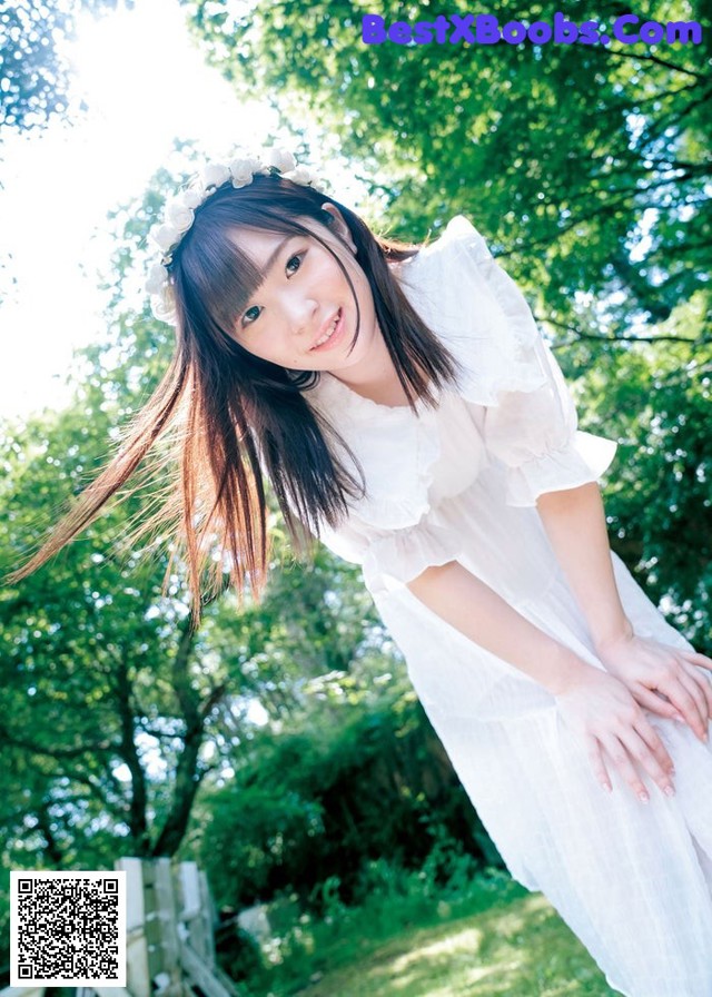 A woman in a white dress posing for a picture.