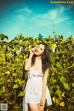 A woman in a white dress posing for a picture.