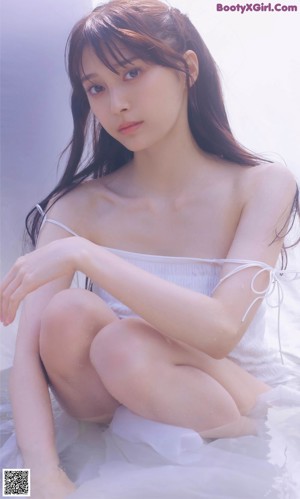A woman in a white dress posing for a picture.
