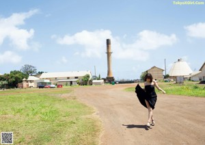 A woman standing on the beach with her hair blowing in the wind.