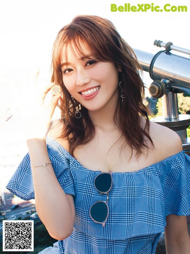 A woman in a blue and white dress posing for a picture.