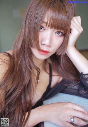 A woman with long brown hair sitting at a table.