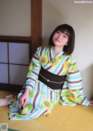 A woman in a kimono holding a popsicle in her hand.