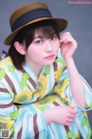 A woman in a kimono holding a popsicle in her hand.