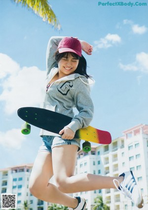 A young woman with long black hair wearing a white hoodie.